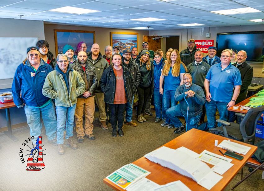 Group of shipyard workers gathered in union office with IBEW Local 2320 logo by IBEW Local 2320